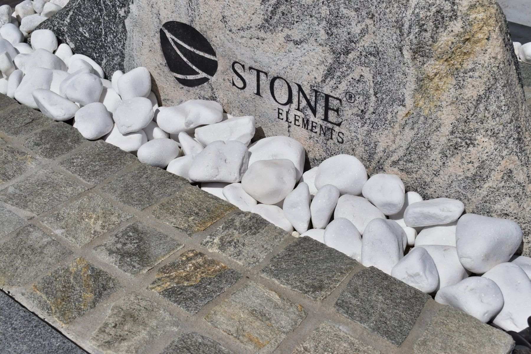 white pebbles large and round at base of garden sculpture