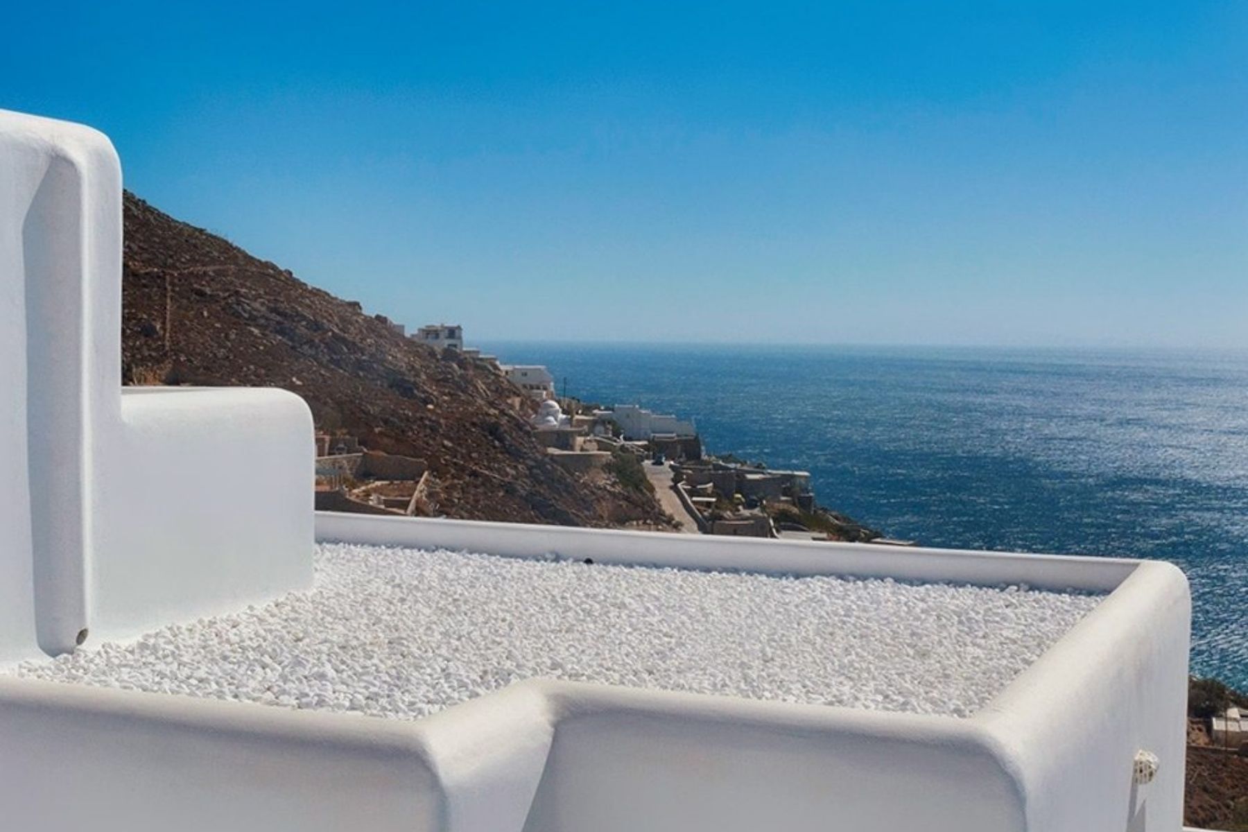 white stone pebbles on roof with ocean view in background