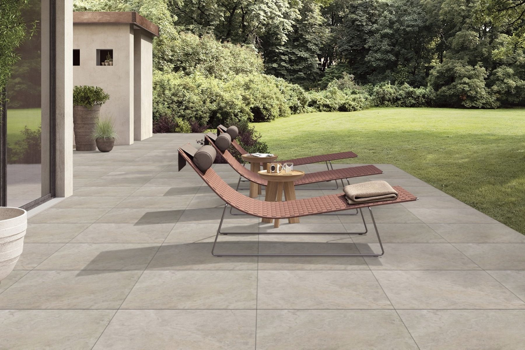 beige travertine porcelain paved flooring with green landscaping background